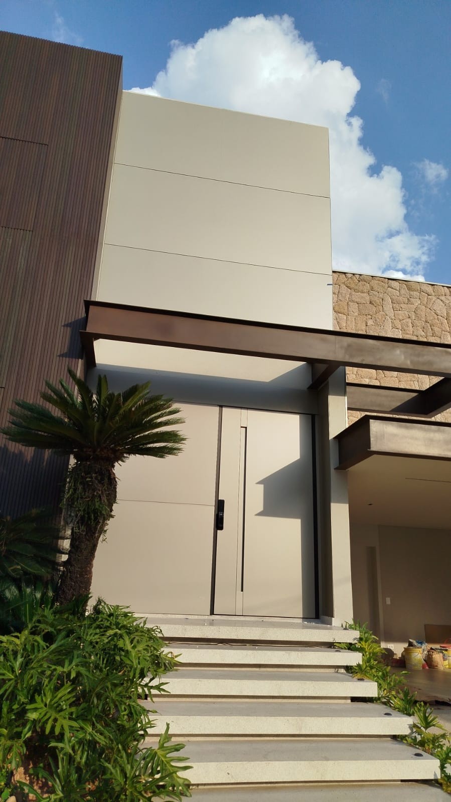 Fachada com revestimento ACM e porta pivotante
