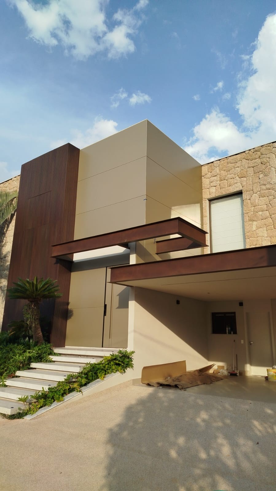 Fachada frontal com revestimento em ACM e brise madeirado