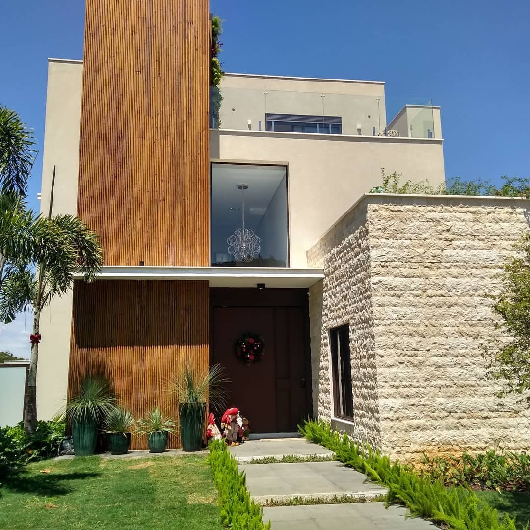 Fachada com jardim vertical e portal ripado