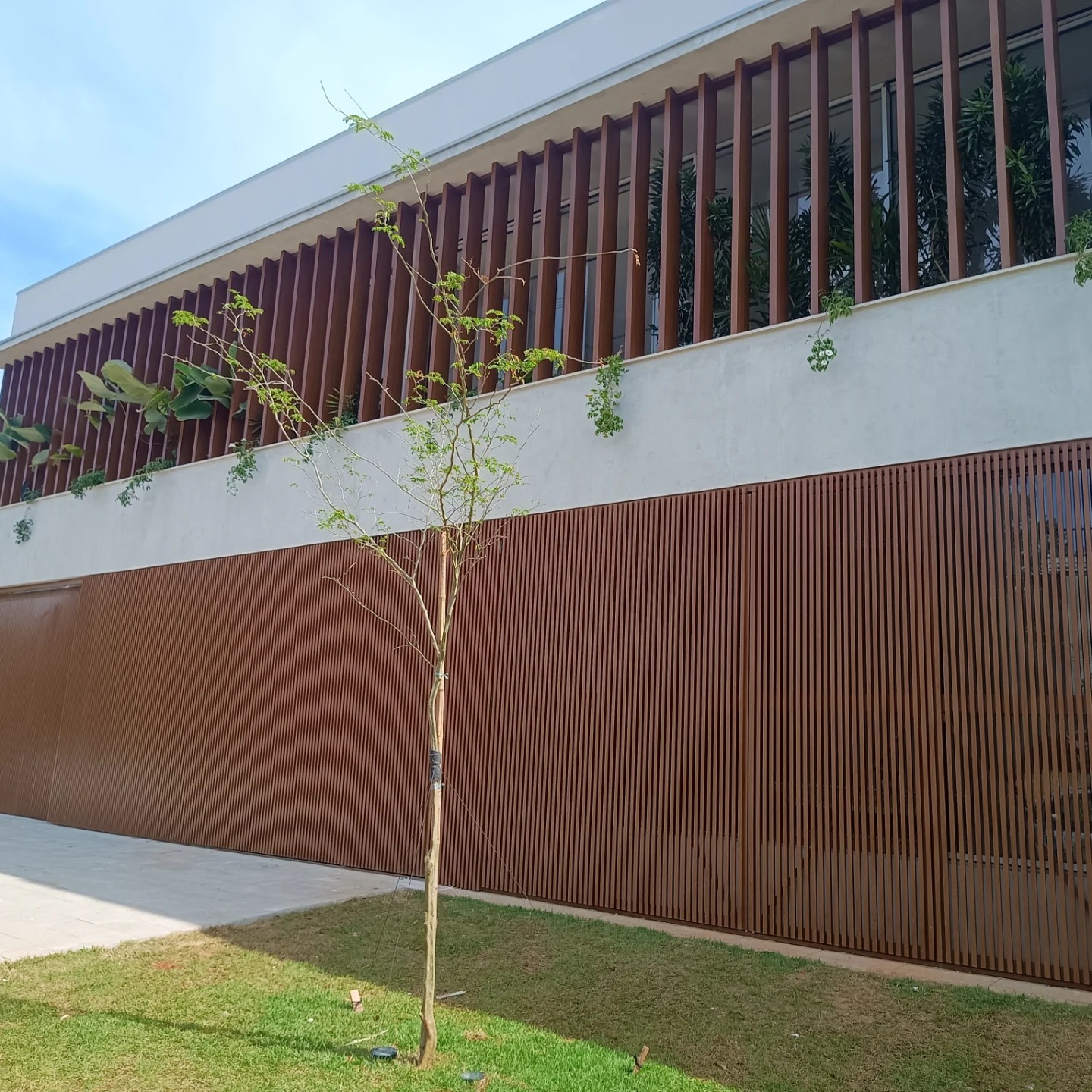 Fachada residencial com brise e jardim
